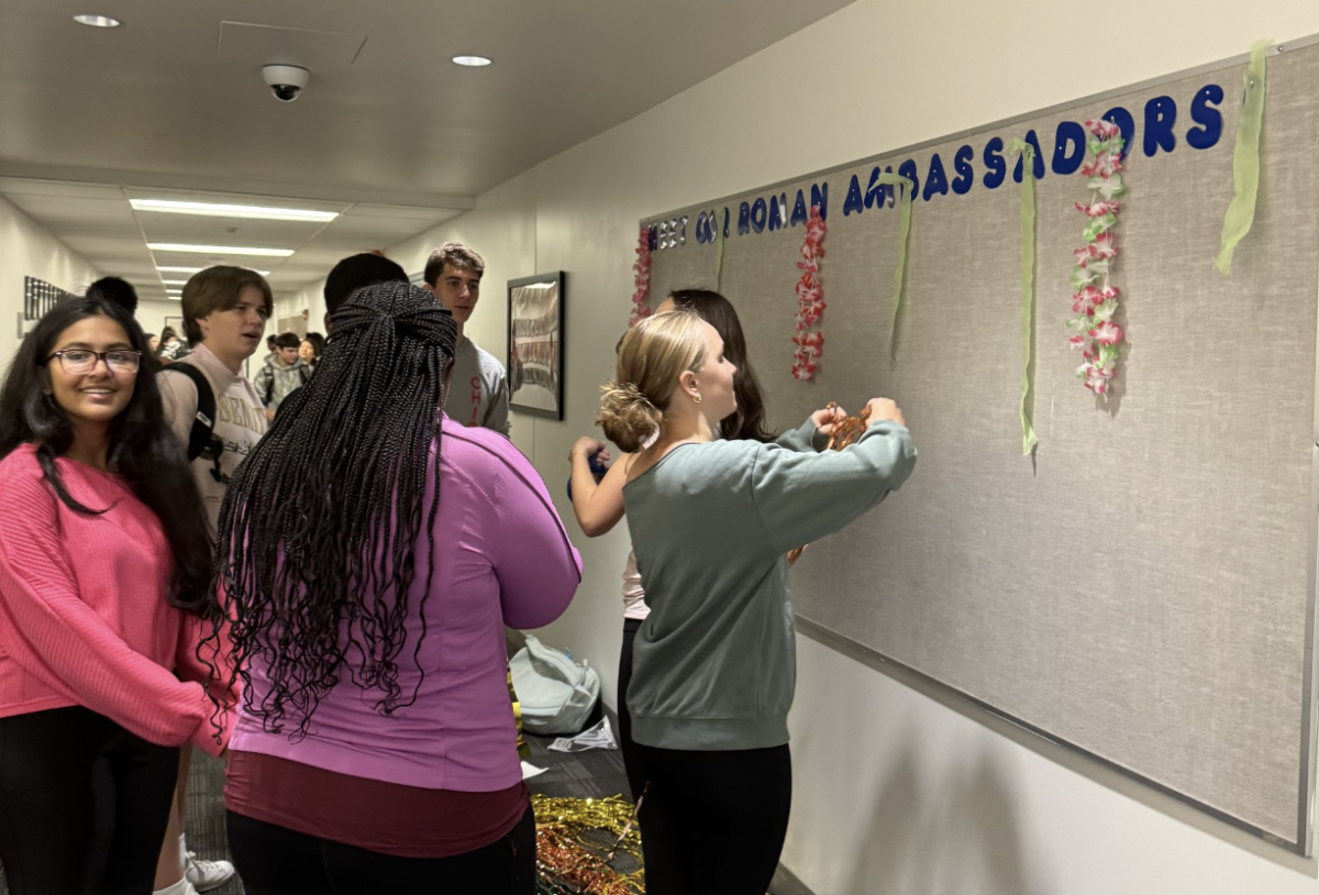 Freshmen embrace the tropical paradise theme by hanging neon green streamers on the second floor walls.